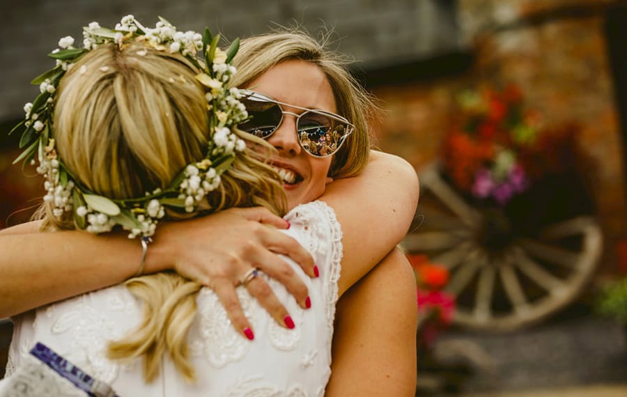 A wedding guest congratulates the bride in the courtyard