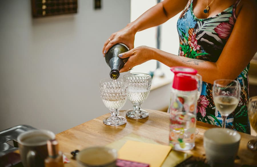 A bridesmaid pours champagne into glasses