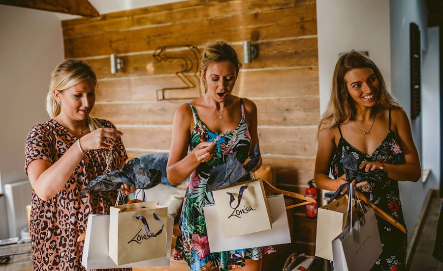 The bridesmaids open their presents given to them by the bride in the cottage at Yurt retreat