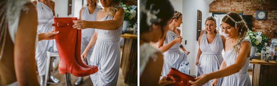 Bridesmaids give the bride a new set of red wellington boots in the kitchen of the cottage
