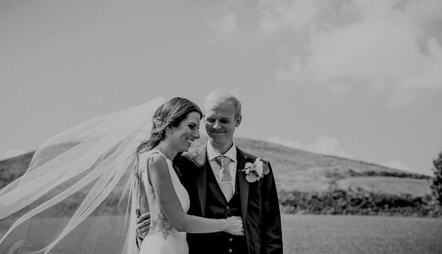 The groom smiles at the bride and puts his arm around her during the wedding ceremony