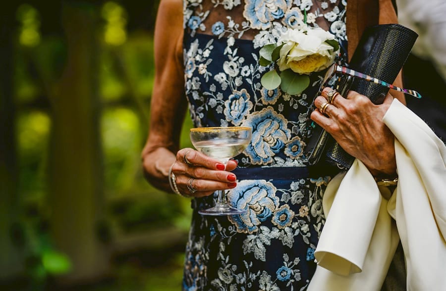 The grooms mother holds a glass of champagne in her right hand