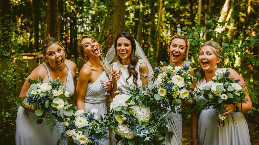 The bride and bridesmaids pose for a photograph with their bouquets