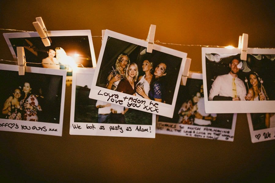 Polaroid photographs of the wedding day hang from string in the tipi at yurt retreat