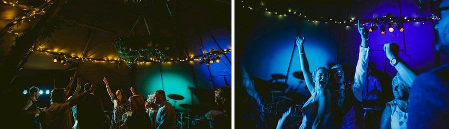 Wedding guests put their arms in the air on the dancefloor in the tipi and dance to a song played by the wedding band