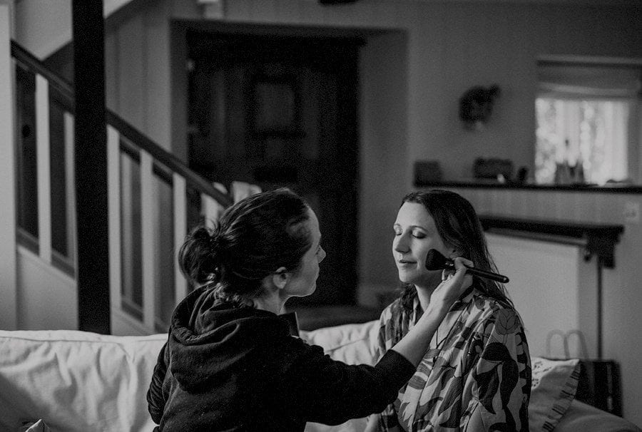 The make up artist applies mascara to the brides cheek