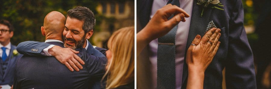 Wedding guests arriving and a lady folds a handkerchief into the breast pocket of an ushers suit