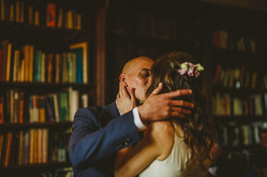 The bride and groom hold each other and kiss during the wedding ceremony