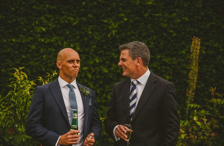 The groom talks with a wedding guest