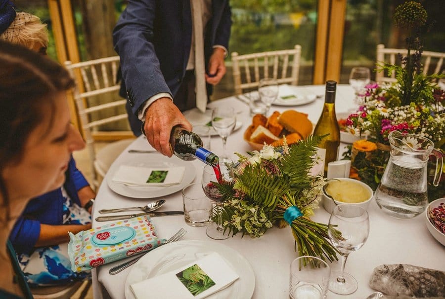 The groom pours the bride a glass of red wine