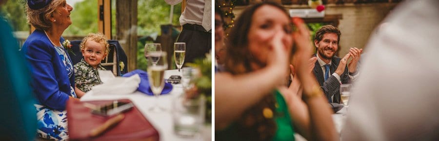The bride and groom's son laughs as he sits on the lap of his grandmother