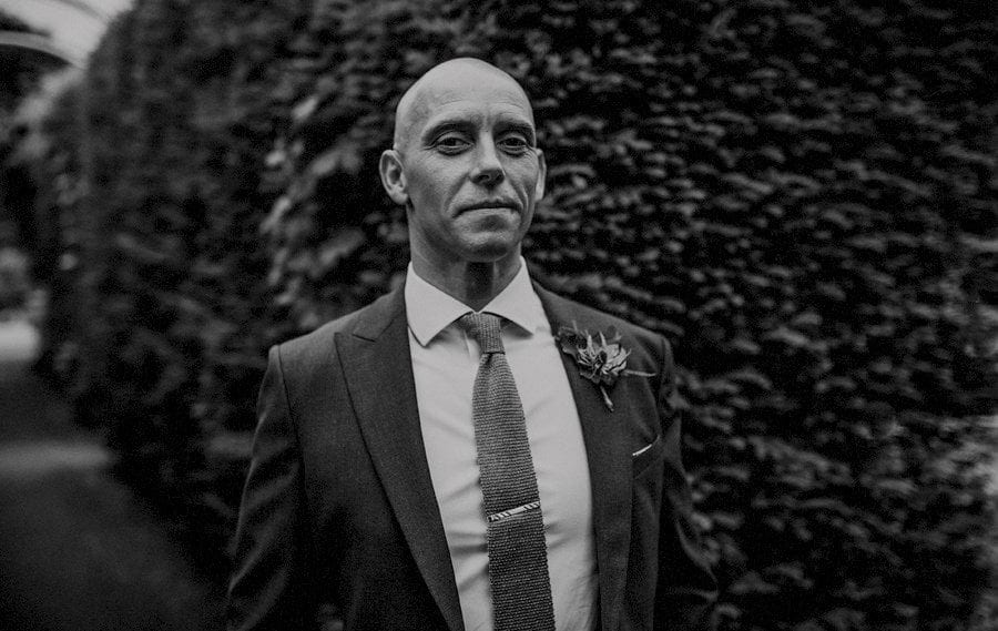 The groom poses for a photograph