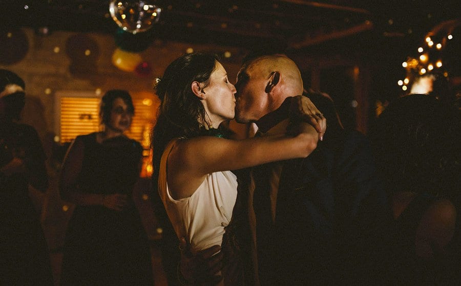 The bride kisses the groom on the dancefloor