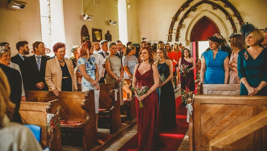 Bridesmaids walking down the aisle of the Church towards the groom