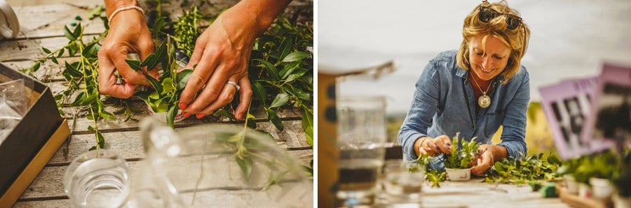 A lady wraps wild flowers on a wooden table outside