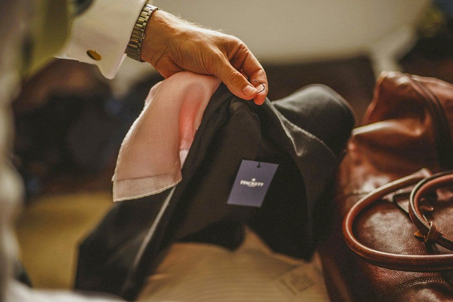 An usher picks up his wedding suit in the hotel room