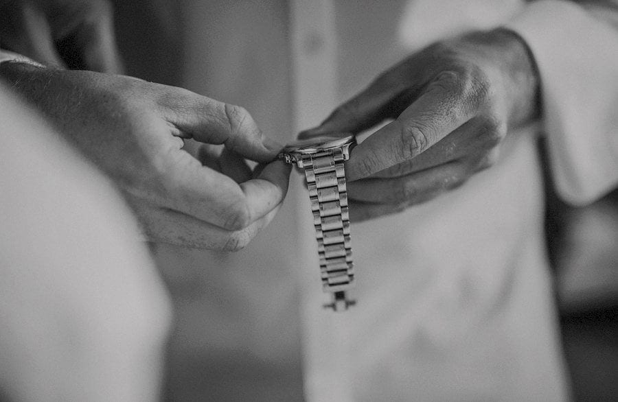 An usher sets his watch to the correct time