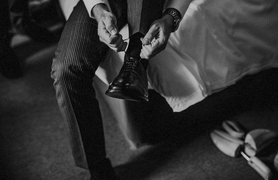 The groom puts his shoes on