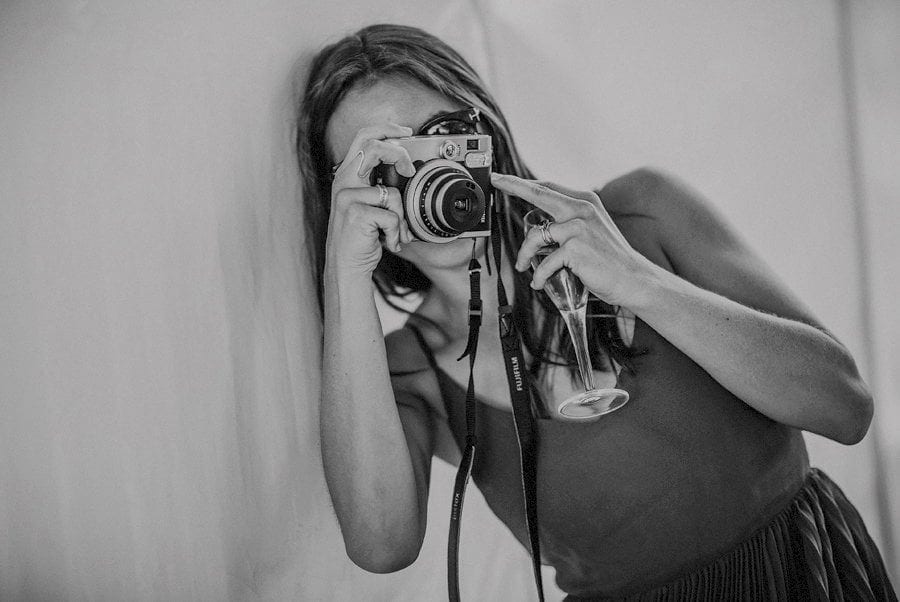 A wedding guest takes a photograph in the marquee