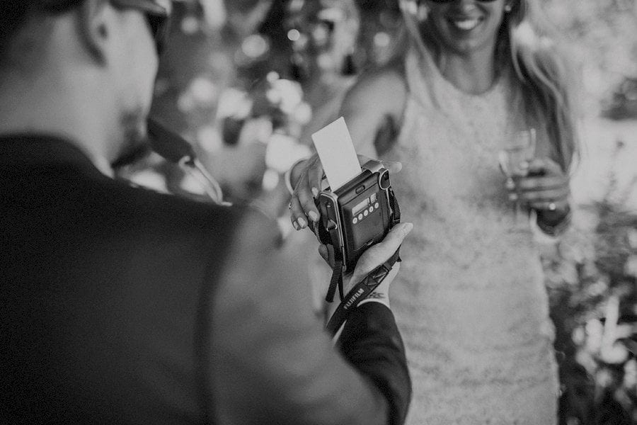 A wedding guest takes a photograph and gives the camera to his friend