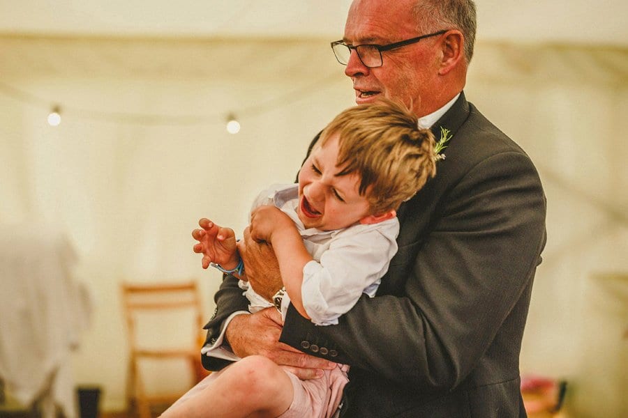The groom's father plays with his grandson.