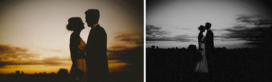 The bride and groom kiss each other as the sun goes down over the Somerset levels