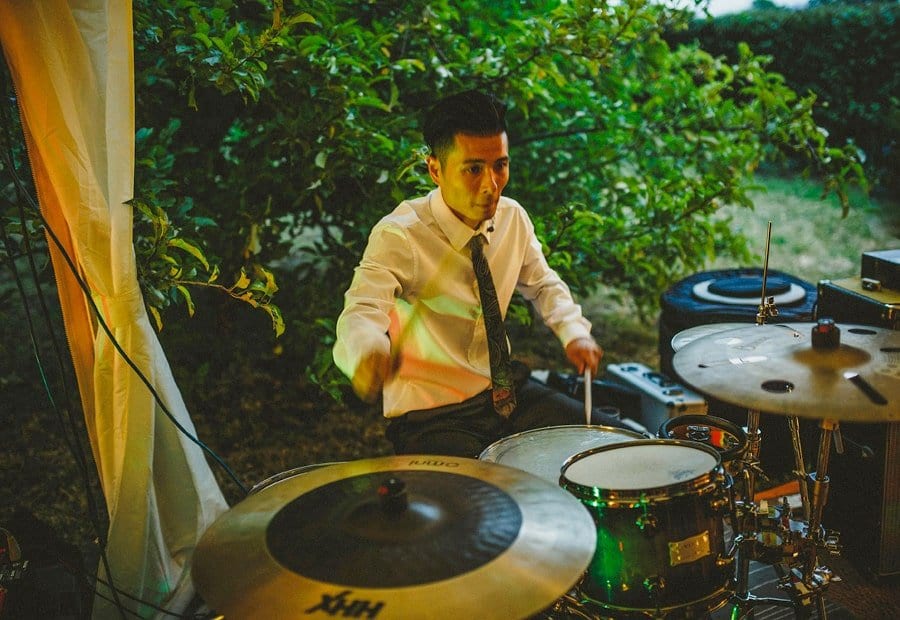 The drummer of the wedding band plays his drums in the marquee