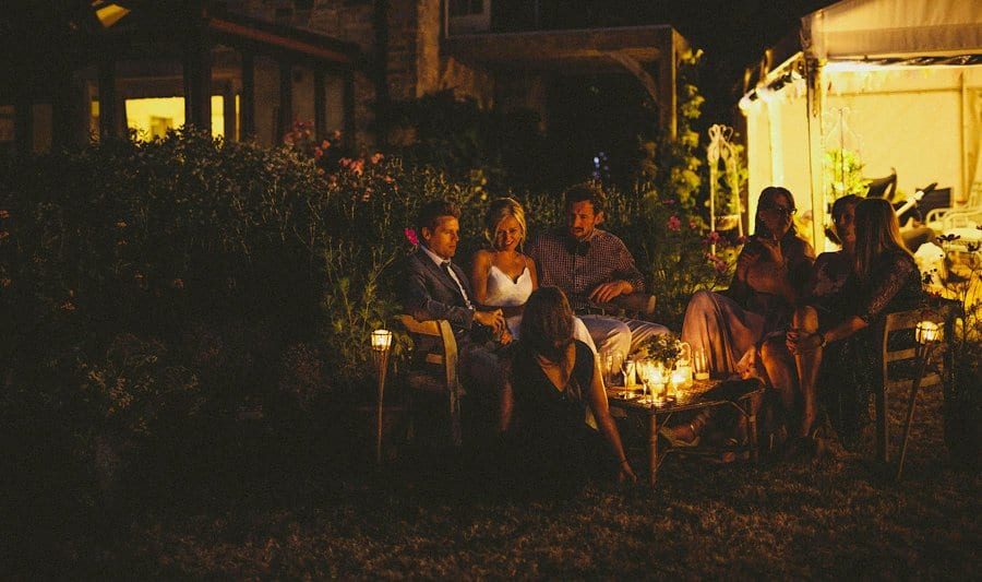 The bride sits around an open fire with her family