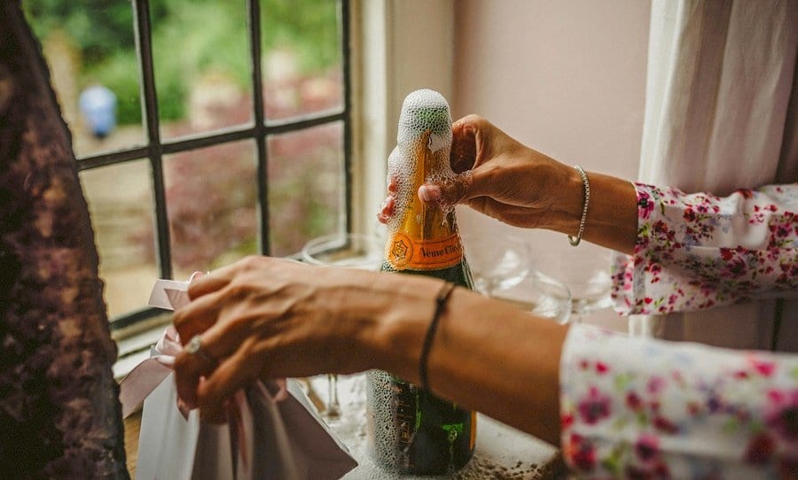 Champagne pours out of the bottle next to a window ledge