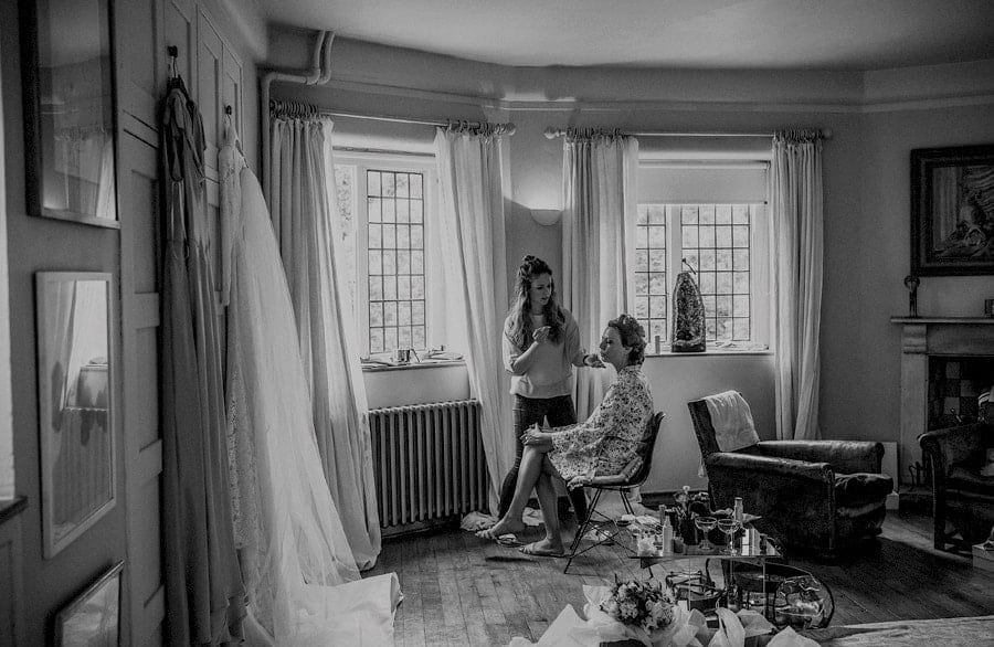 The make up artist applies mascara to the brides face