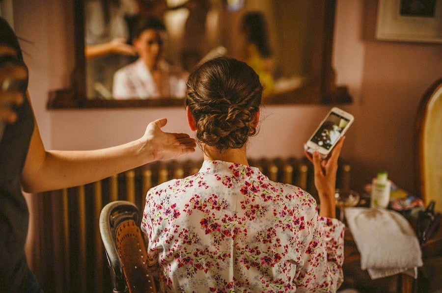The hairdresser straightens the back of the brides hair
