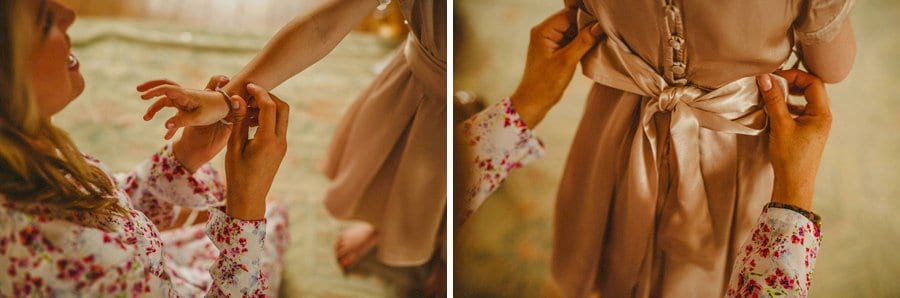 A bridesmaid fastens the ribbons to the back of the flower girls dress