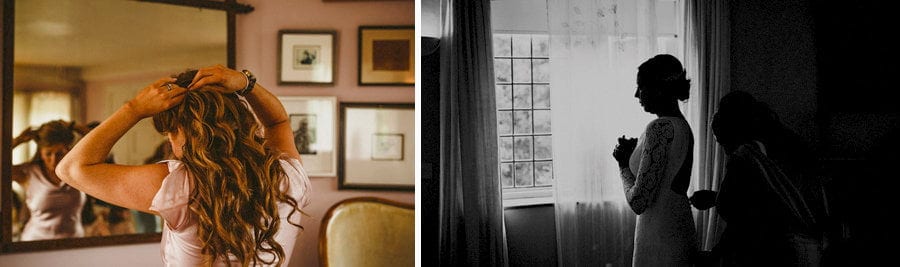 A bridesmaid fastens the back of the brides dress in the bridal suite