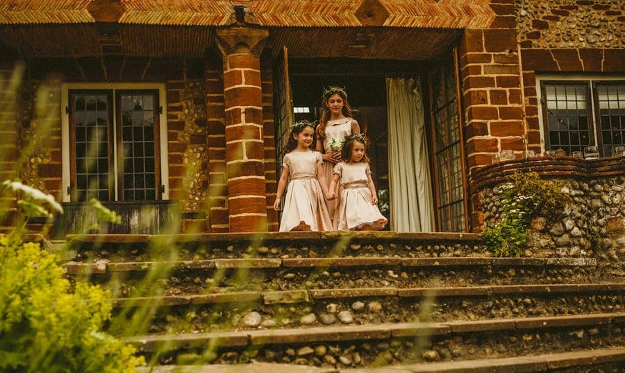 The flower girls leave the house and start to walk down the stone steps
