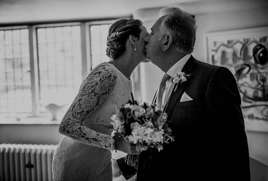 The bride kisses her father before they leave for the outdoor ceremony at Voewood in Norfolk