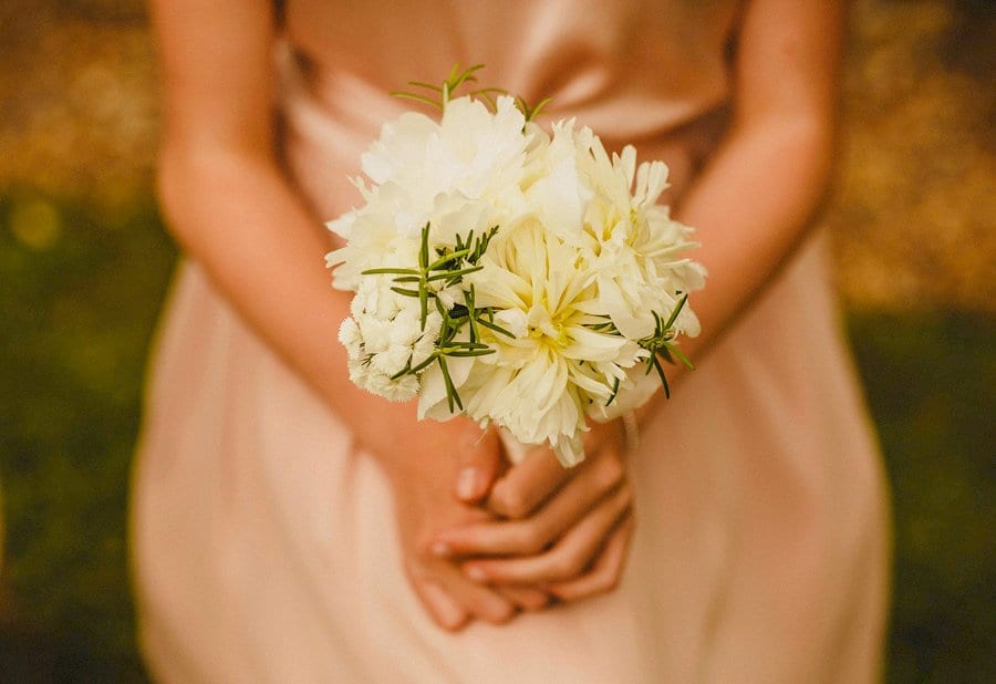 A flower girl holds her flower in both hands