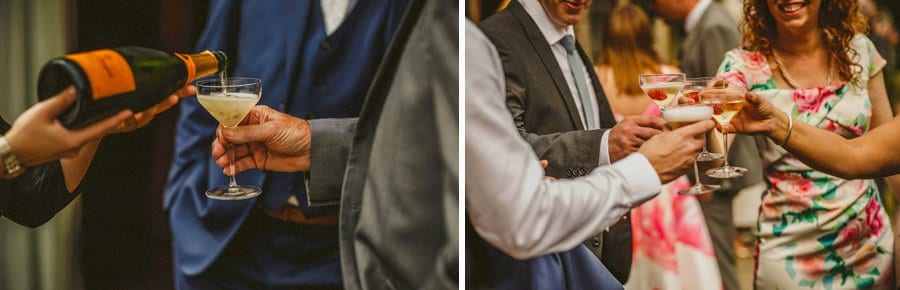 Wedding guests place their champagne glasses together and make a toast