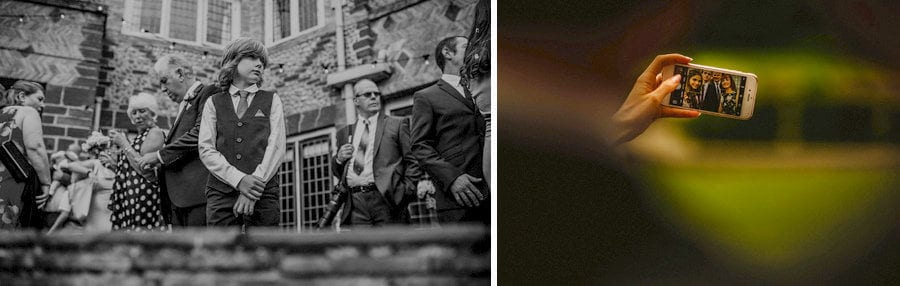 A wedding guest takes a photograph of the bride and groom on their mobile phone