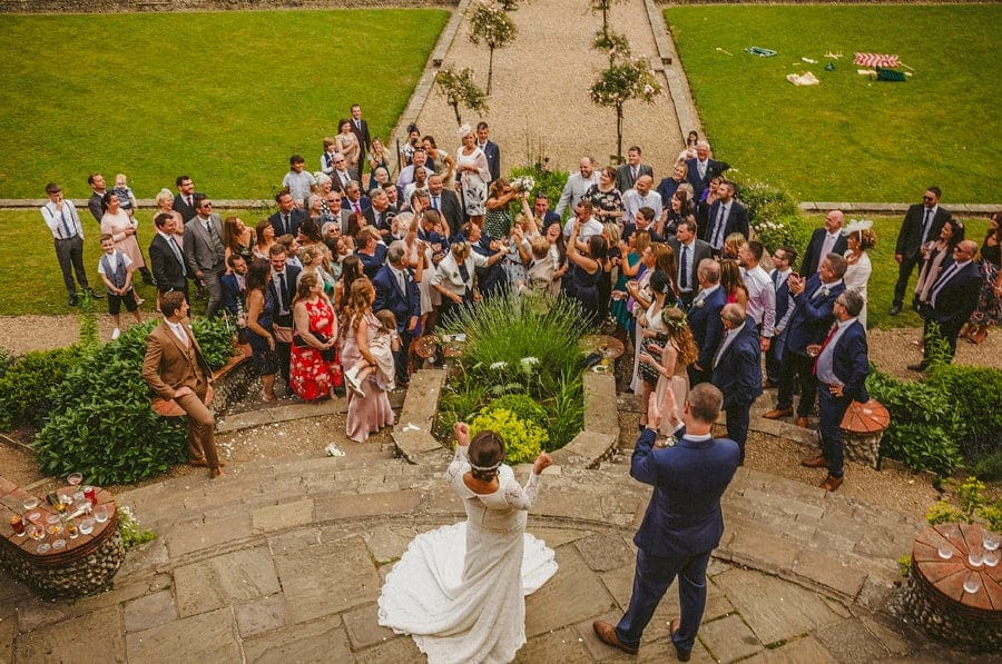 A wedding guest catches the bouquet thrown by the bride on the steps at Voewood