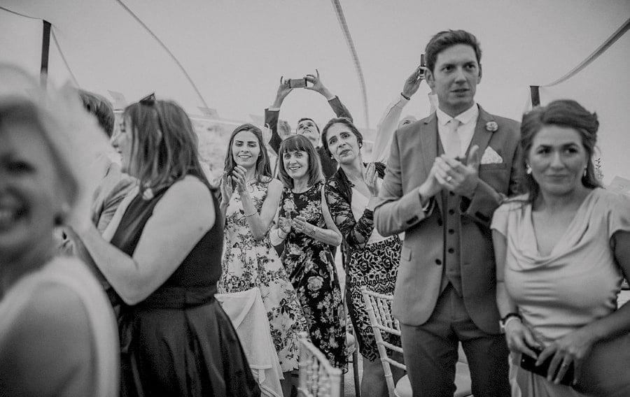 The bride and groom enter the marquee at Voewood and the wedding guests stand and applaud