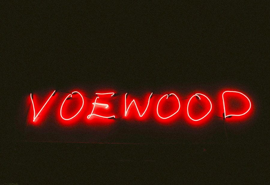 A neon sign which reads VOEWOOD