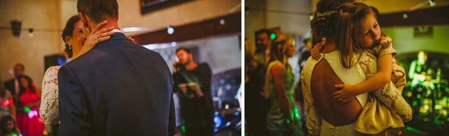 The bride holds a flower girl in her arms on the dancefloor at Voewood