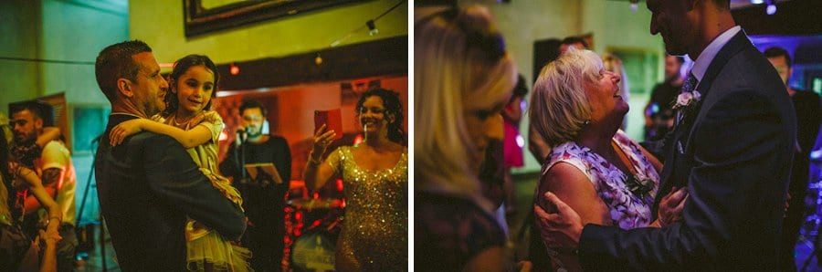 The groom holds a flower girl in his arms on the dancefloor