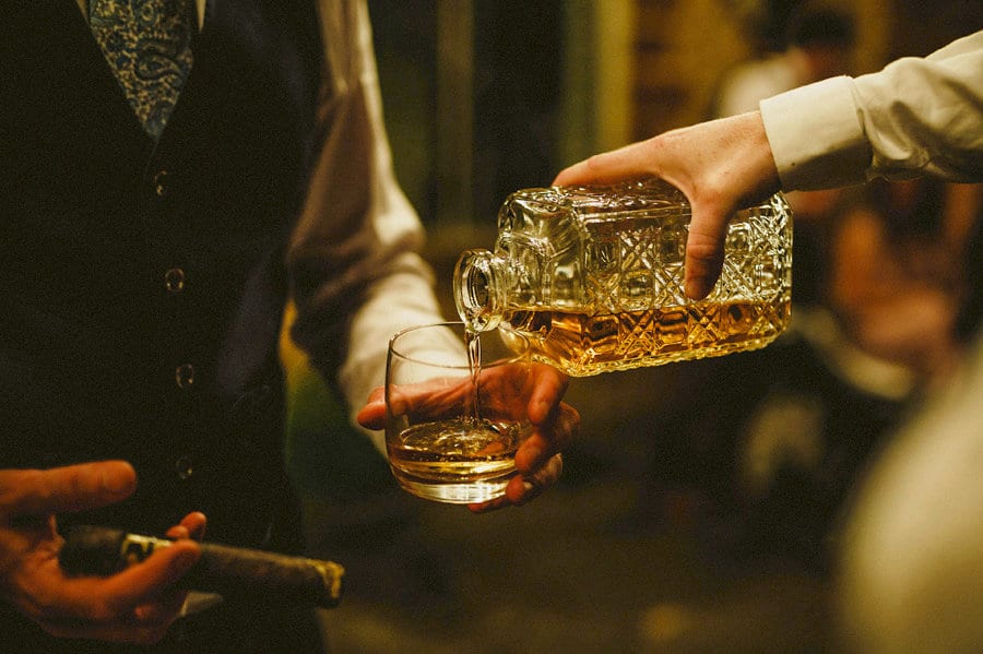An usher pours whisky into a glass