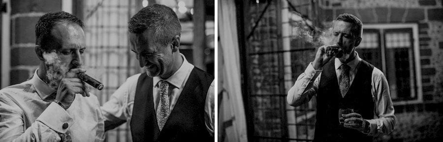 An ushers smokes a cigar as the groom watches and smiles