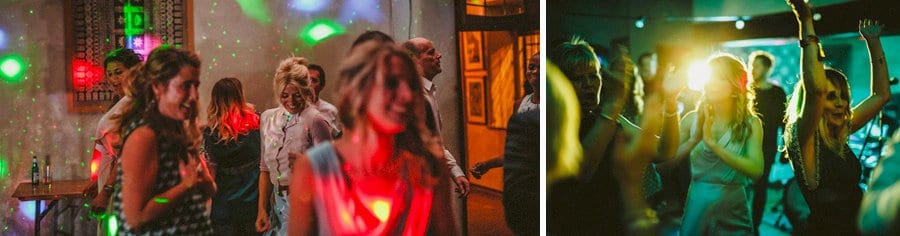 Wedding guests raise their arms in the air on the dancefloor