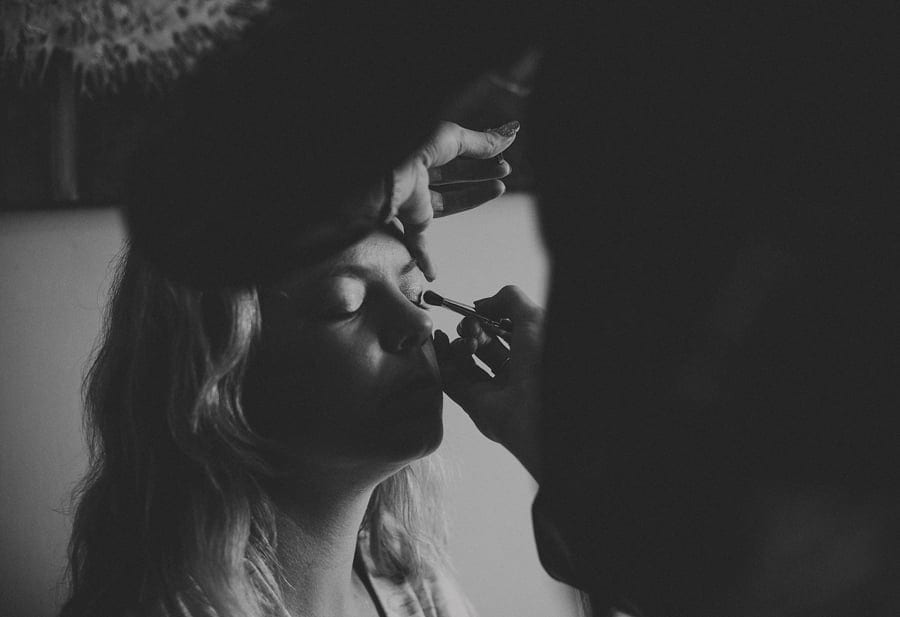 The bride has mascara applied to her eye lids