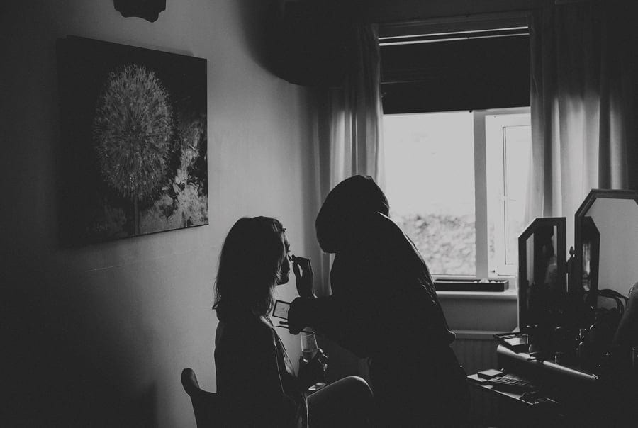 The make up artist applies make up onto the brides face