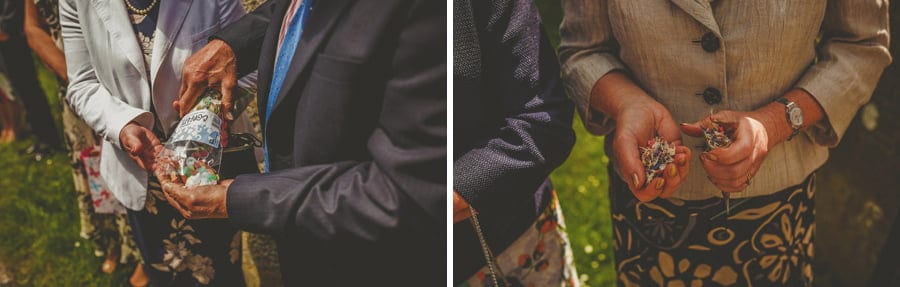 Wedding guests hold confetti and wait for the bride and groom to leave the church