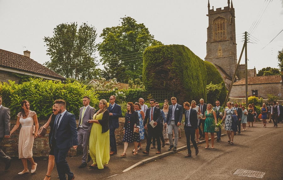 Wedding guests leaving the church and walking down the street
